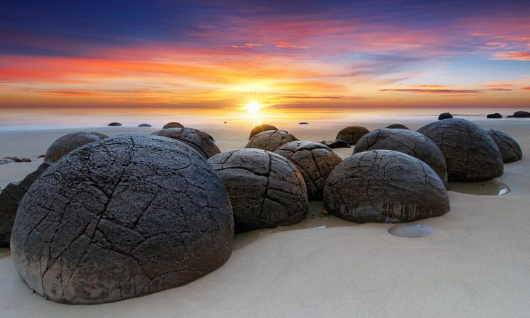 Jajaran hamparan batu bulat pantai Koekohe. Legenda mengatakan ia adalah telur naga laut yang hanyut ke pesisir pantai
